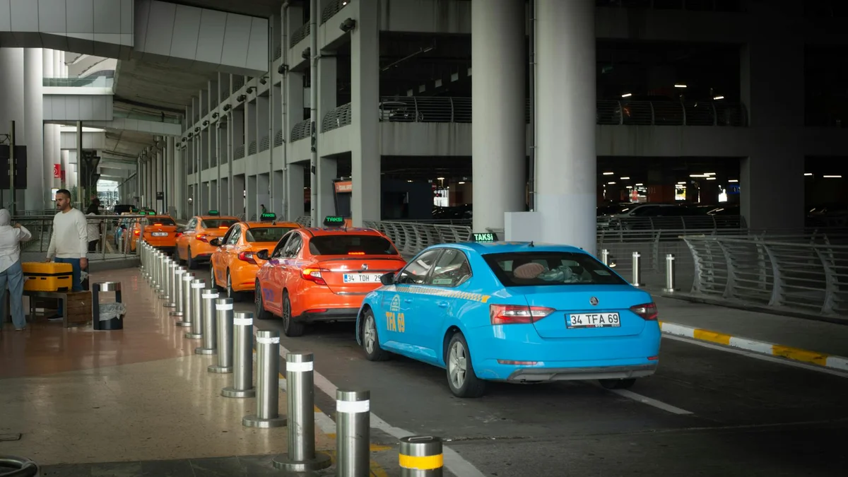 Taxi negro frente a entrada de metro en aeropuerto urbano con viajeros llegando con maletas